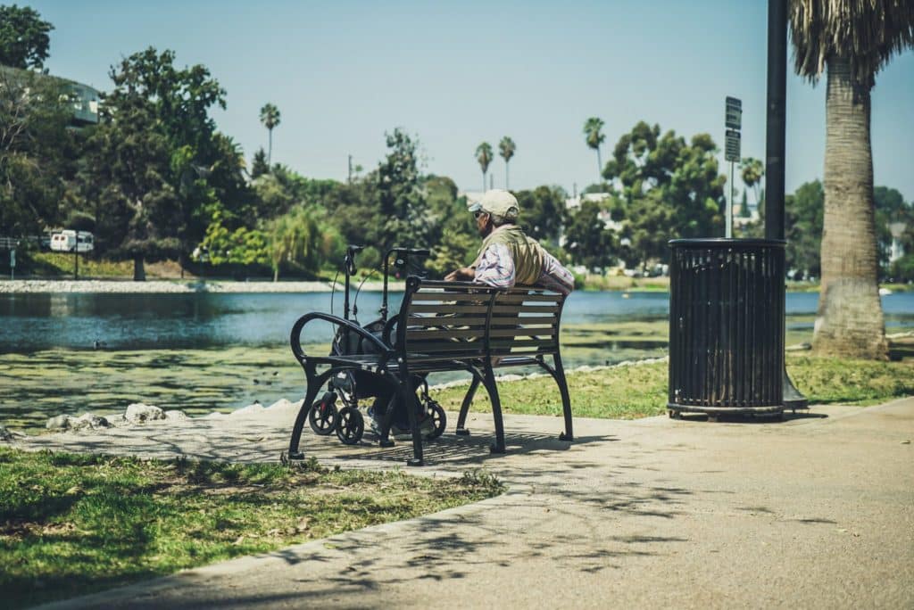 Old retired men is sitting on the park bench at Echo Park in Los Angeles